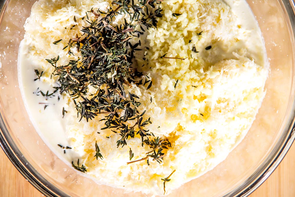 Cheese, Cream, Fresh Thyme & Minced Garlic in a Bowl