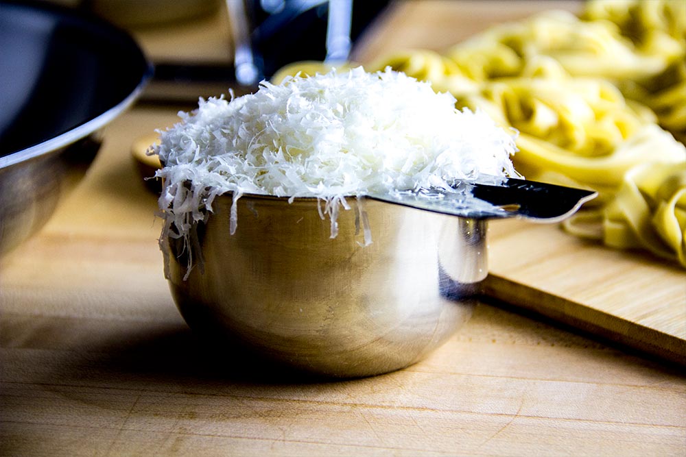 Grated Parmesan Cheese in Stainless Steel Measuring Cup