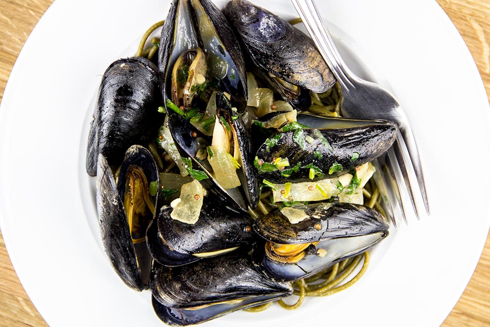 Cooked Mussels Over a Bed of Spinach Spaghetti