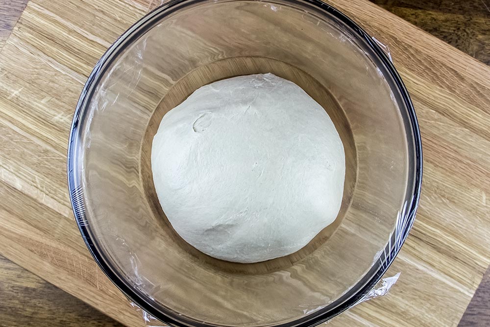 Rising Dough in Large Bowl Covered with Plastic Wrap