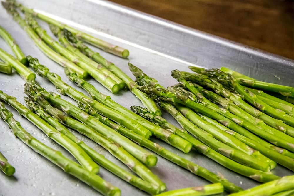 Raw Asparagus Spread Out on Baking Sheet
