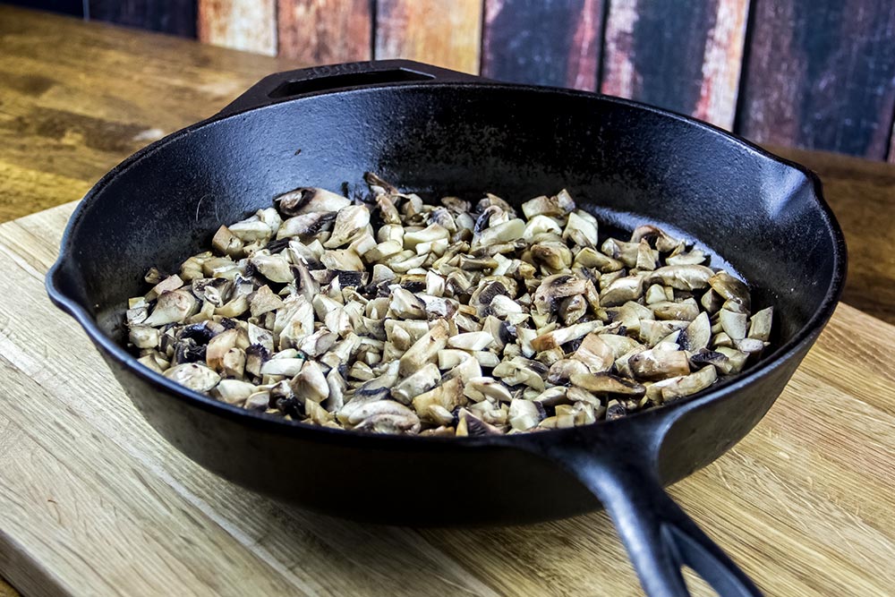 Chopped White Button Mushrooms in Cast Iron Skillet