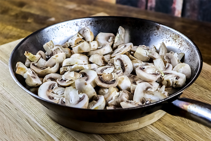 White Button Mushrooms in Stainless Steel Skillet